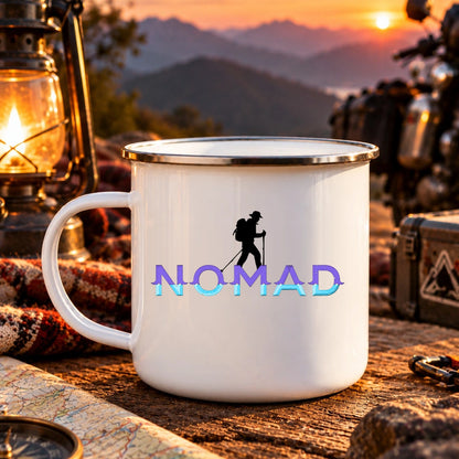 Nomad 300 ml white enamel camping mug with original purple and cyan wordmark and black mountaineer silhouette at sunset