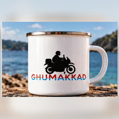 Front view of GHUMAKKAD white enamel motorcycle mug with double-sided biker design and ocean background