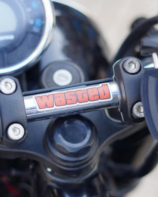 Close-up of a motorcycle handlebar with 'wasted' branding.
