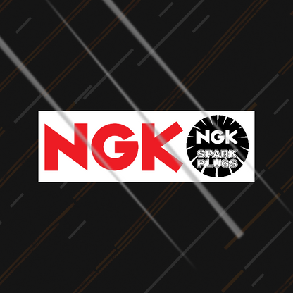 NGK Spark Plugs sticker on a black background with diagonal lines