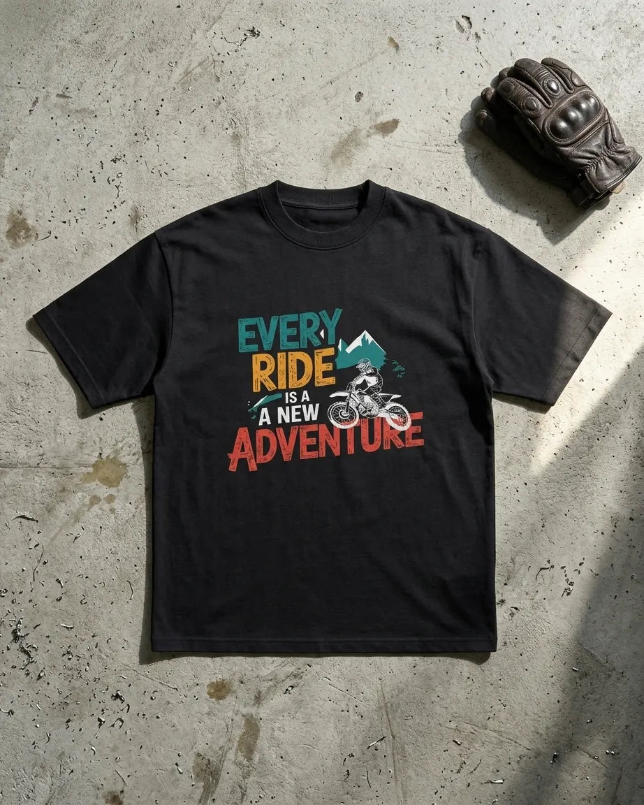 Every Ride Is A New Adventure black oversized t-shirt flat lay with riding glove on concrete