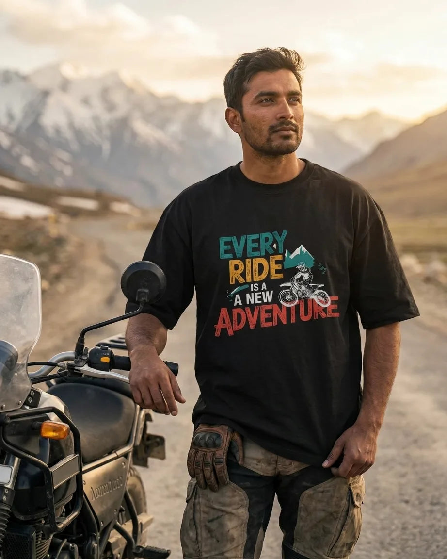 Every Ride Is A New Adventure black oversized t-shirt worn by adventure rider with motorcycle in Himalayan mountain pass
