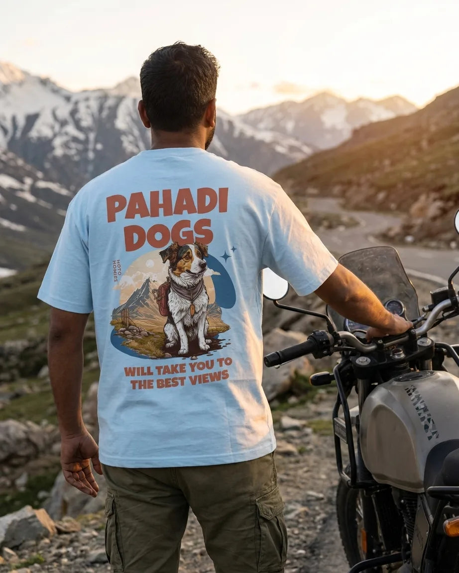 Pahadi Dogs blue oversized t-shirt worn by rider at mountain pass with motorcycle