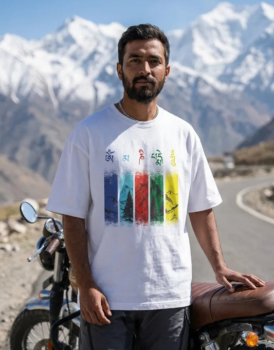 Om Mani Padme Hum white oversized t-shirt worn by Royal Enfield Himalayan rider in snow-capped mountains