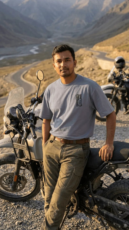Indian adventure rider with Royal Enfield Himalayan motorcycle wearing Stance Outlaws coilover tee at high altitude pass